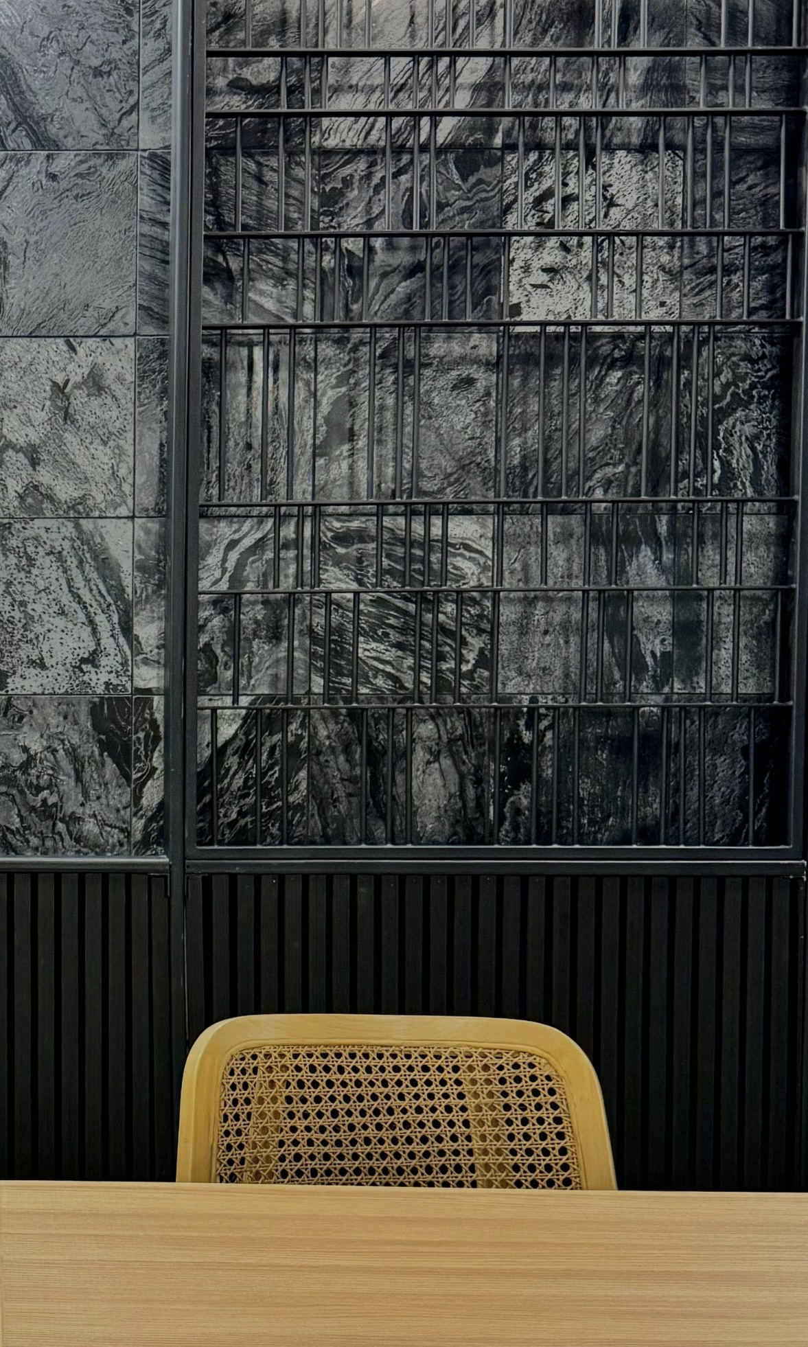 Ginsoy Houston — close-up of the marble feature wall with its black metal grid framing