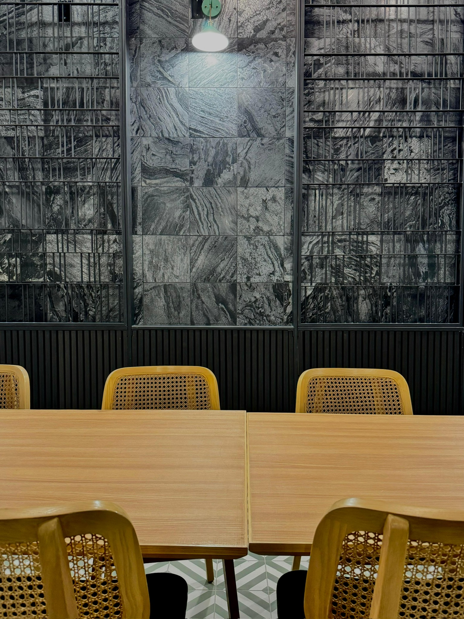 Ginsoy Houston — pair of dining tables against the dramatic black-and-grey marble feature wall