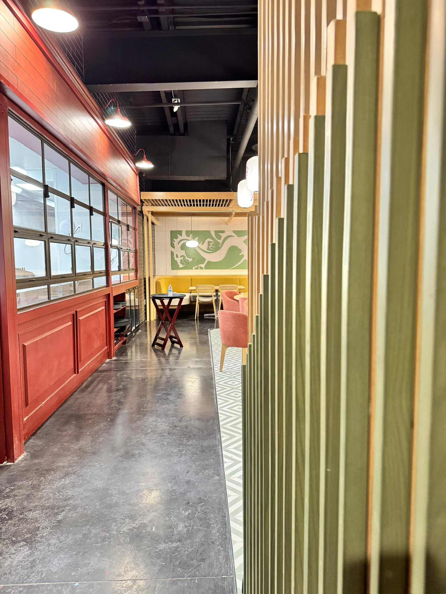 Ginsoy Houston — entry corridor with cinnabar-red shopfront joinery and a green vertical-fin timber screen